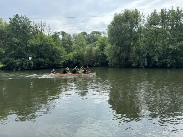 Ein Kanadier mitten auf dem Fluss, umrahmt von Bäumen