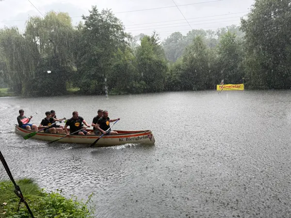 Ein Kanadier mit SÜDKOLA-Mannschaft paddelt durch strömenden Regen über die Enz