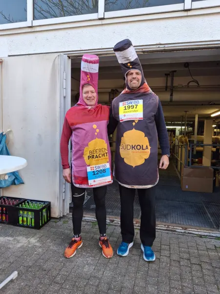 Eine BEERENPRACHT- und eine SÜDKOLA-Flasche mit Startnummern vor dem Lauf