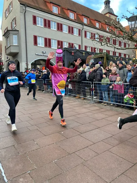 Eine BEERENPRACHT-Flasche winkt den Zuschauern vor dem Rathaus zu